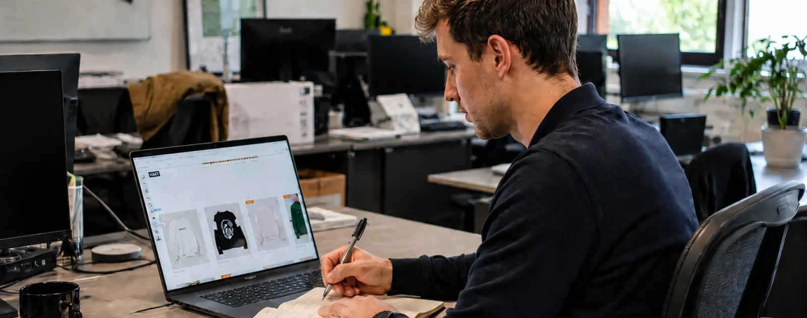 E-commerce operator working on an online store beside real products